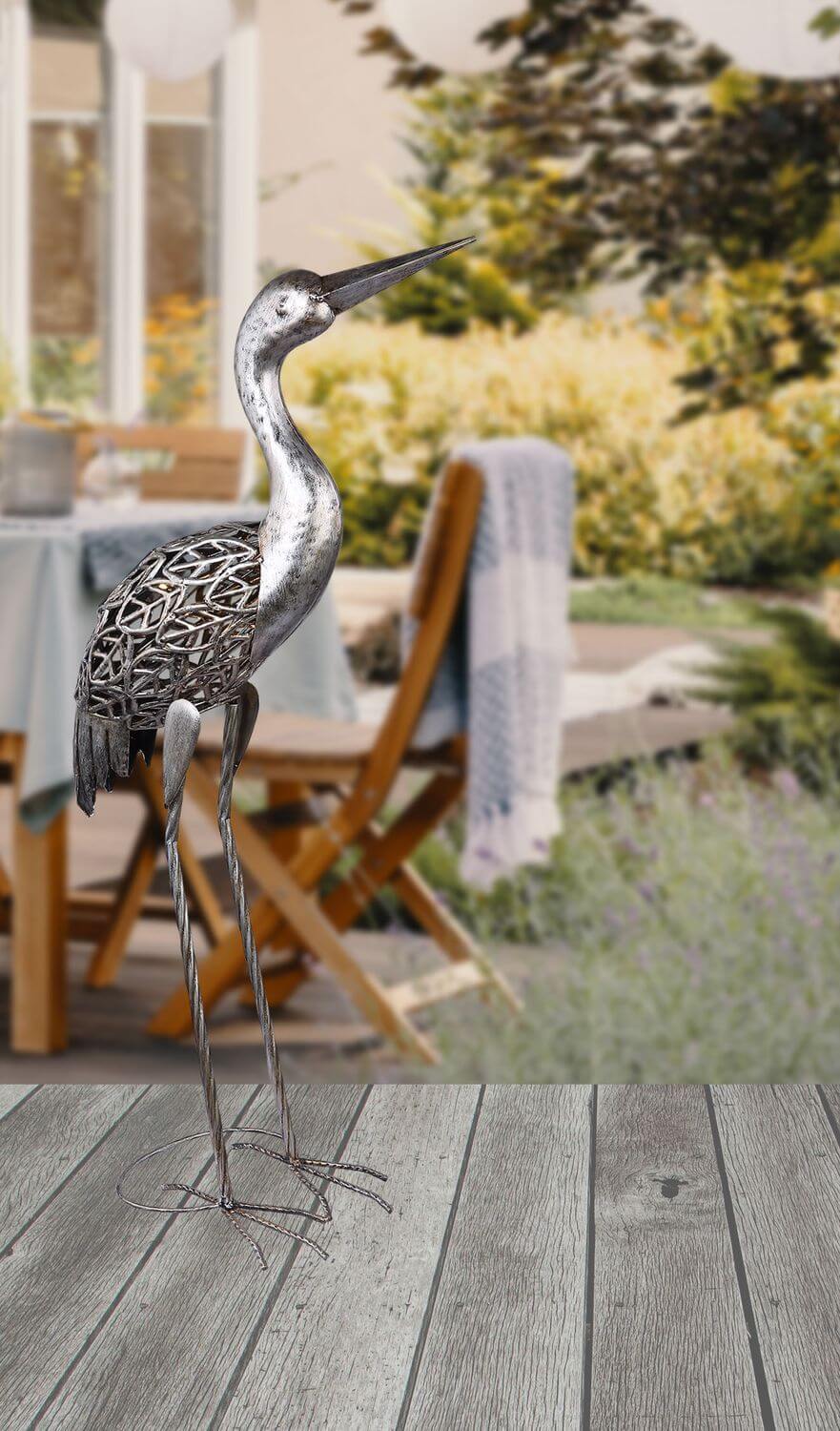 Mise en ambiance du luminaire solaire dans un jardin, posé sur une terrasse en bois.