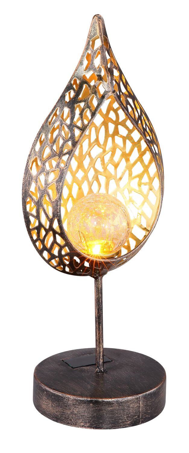 Lampe vue de trois quarts, abat-jour métal ajouré et boule de verre éclairée