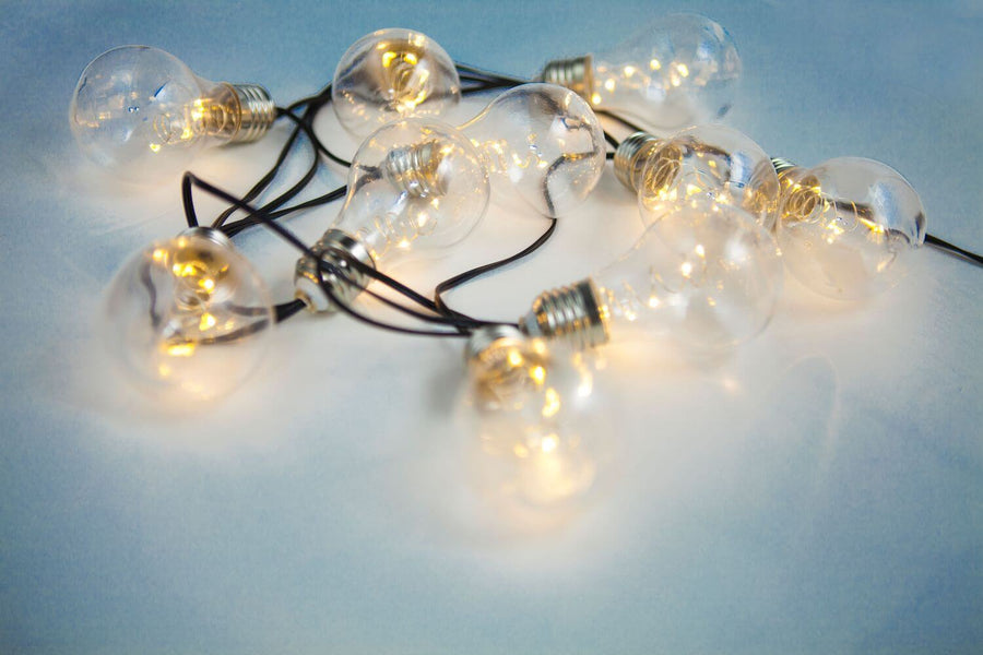 Détail rapproché des ampoules transparentes et filaments lumineux sur fond clair
