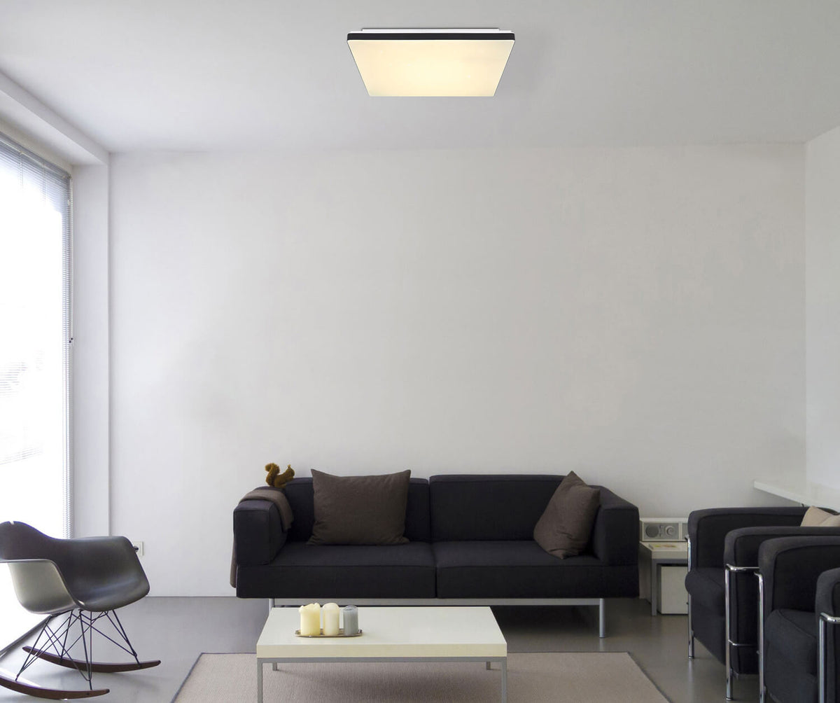 Mise en ambiance dans un salon moderne, plafonnier carré fixé au plafond blanc.