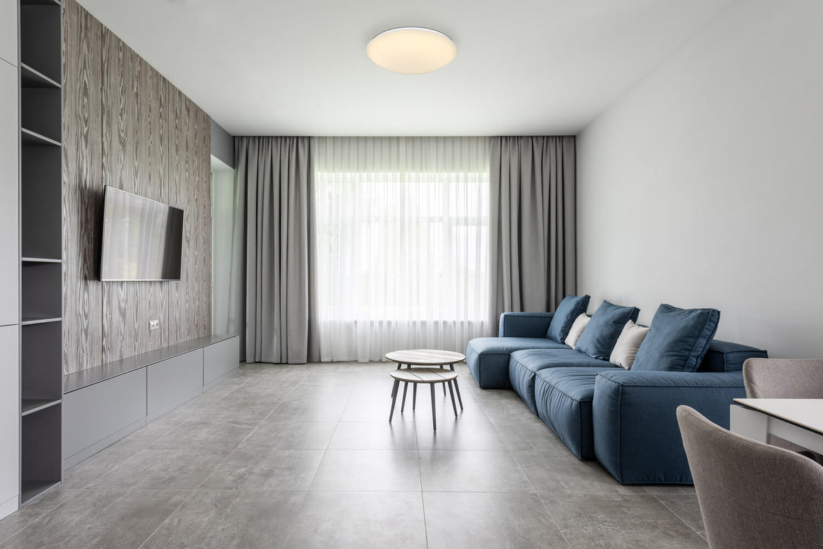 Mise en ambiance du plafonnier allumé dans un séjour contemporain gris et bleu