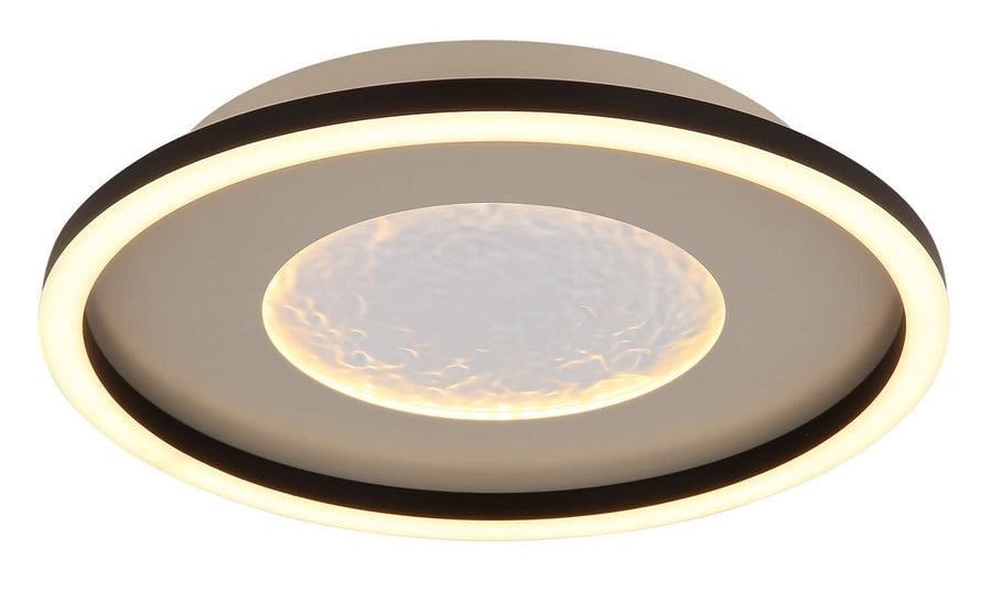 Plafonnier allumé, anneau périphérique lumineux et halo chaud au centre texturé.