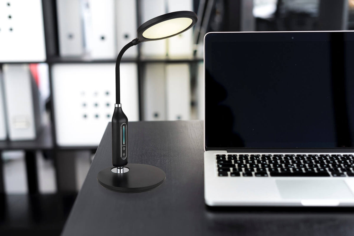 Mise en ambiance sur un bureau sombre, à côté d'un ordinateur portable ouvert