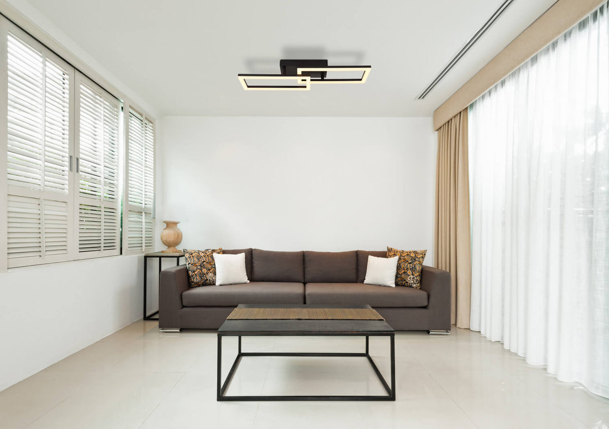 Mise en ambiance dans un salon moderne, plafonnier allumé au-dessus du canapé