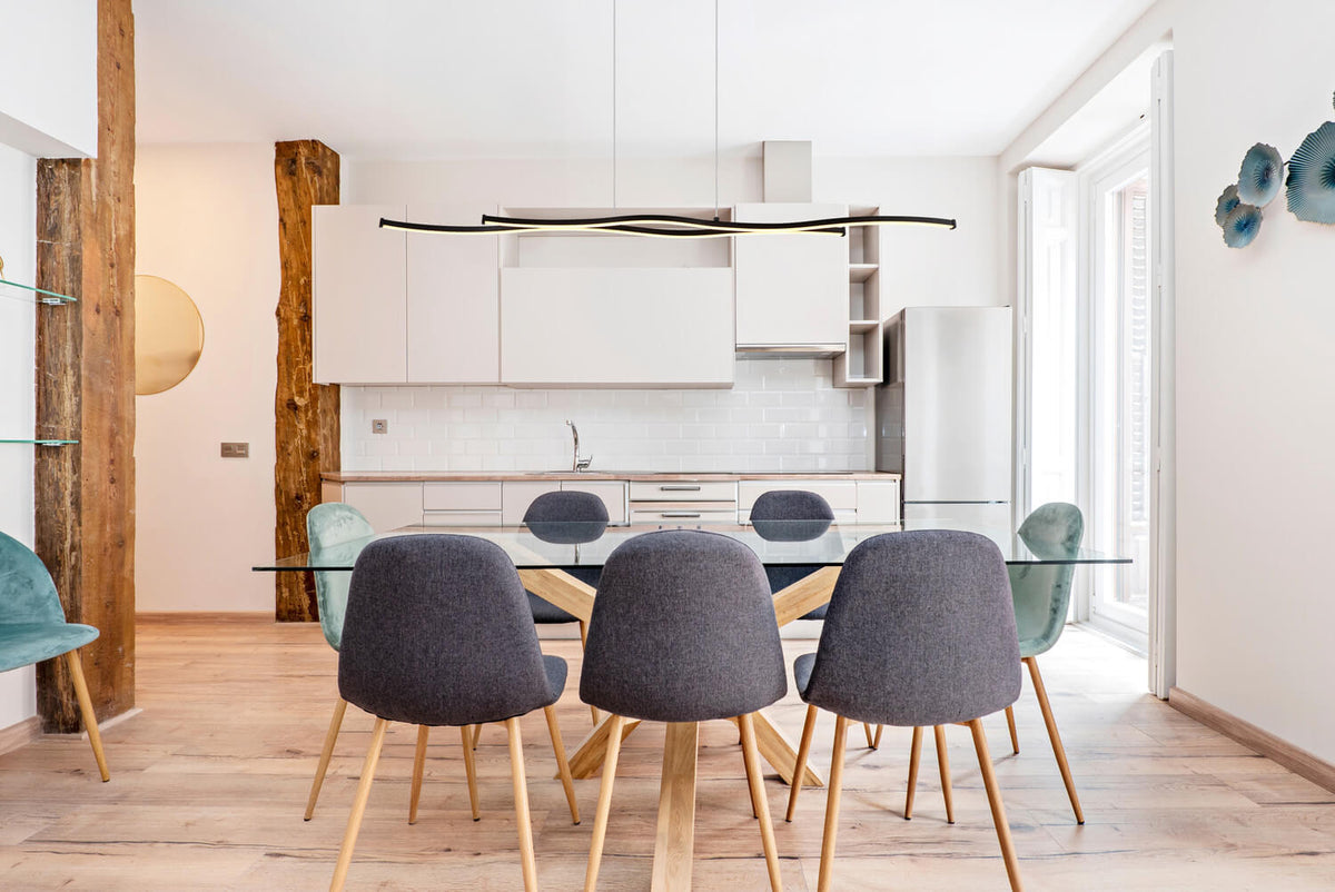 Mise en ambiance au-dessus d'une table dans une cuisine ouverte lumineuse et moderne.