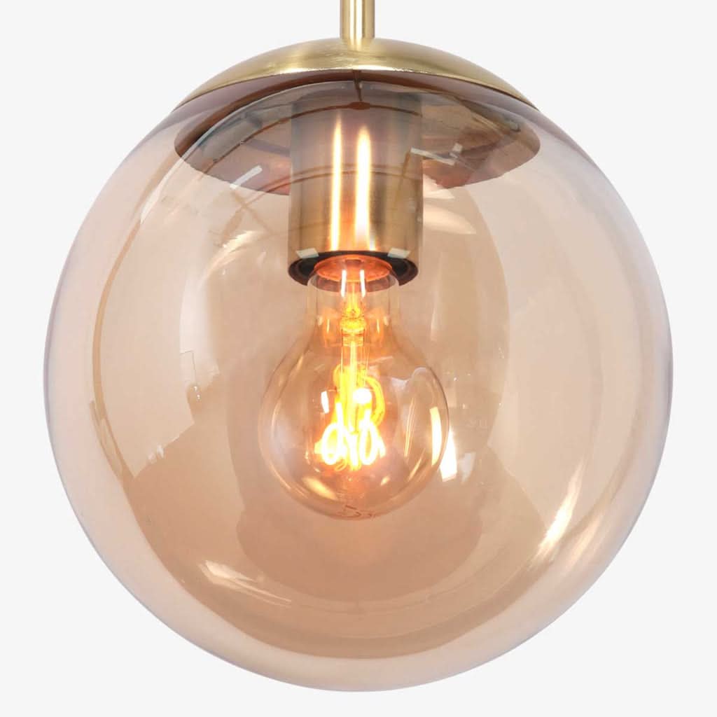 Gros plan sur l'ampoule à filament allumée à l'intérieur de la sphère ambrée