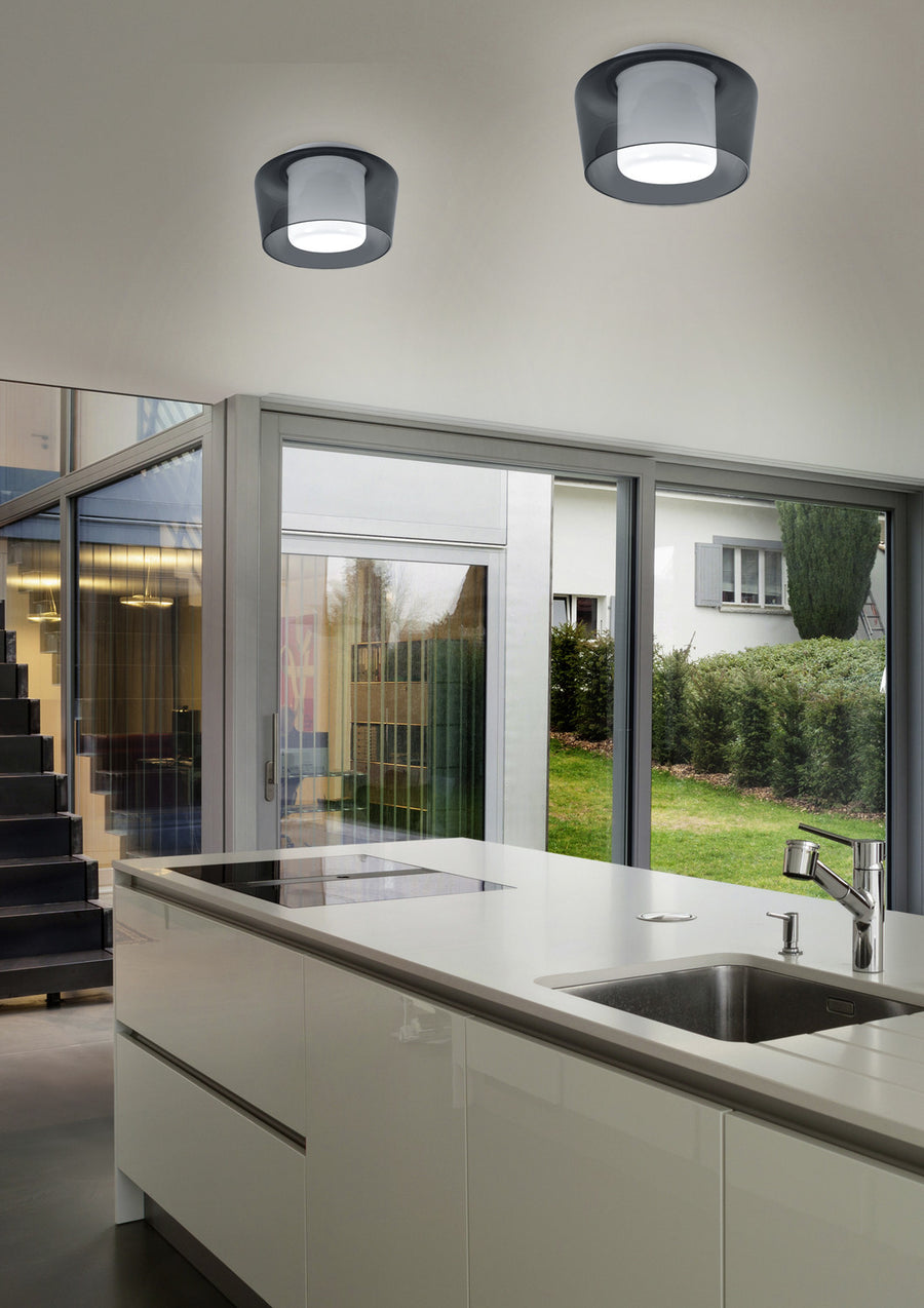 Deux plafonniers blancs installés au plafond dans une cuisine moderne avec baies vitrées.
