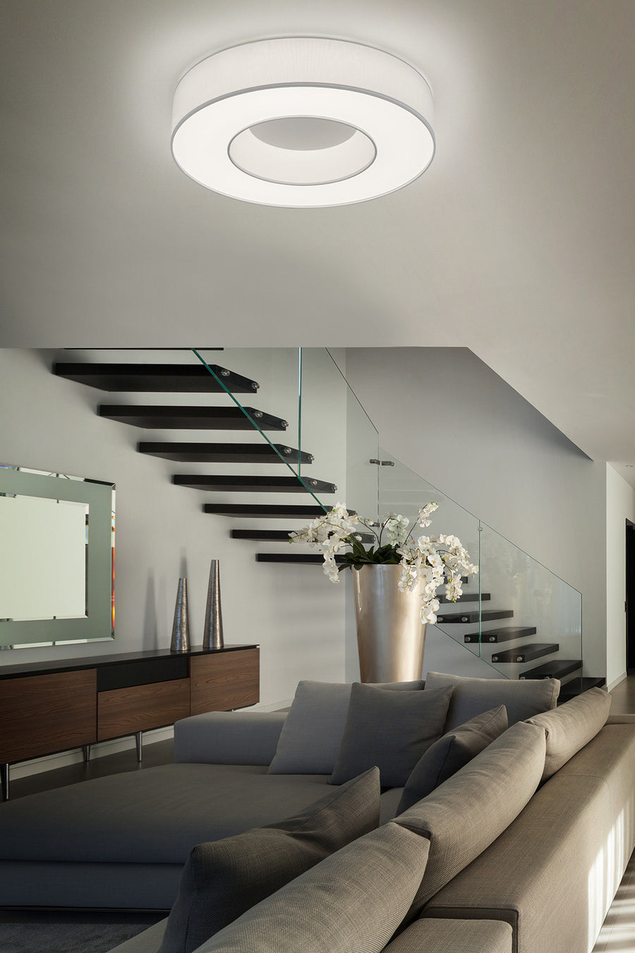 Plafonnier blanc installé au plafond d'un salon contemporain avec escalier