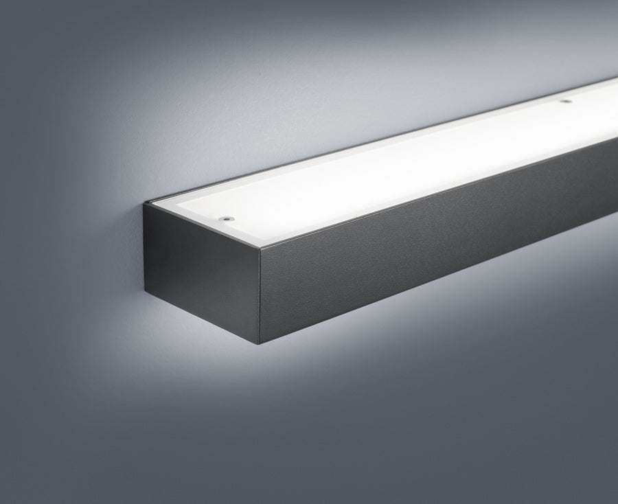 Détail de la finition : boîtier aluminium noir texturé et diffuseur blanc opaque
