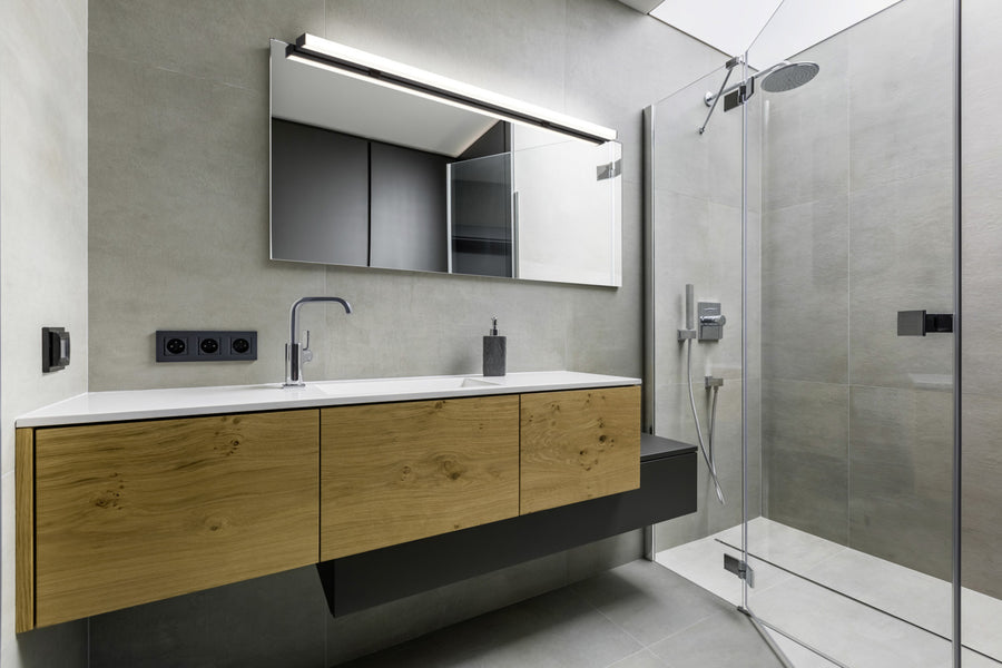 Vue d'ensemble de la salle de bain avec meuble bois, miroir et douche vitrée