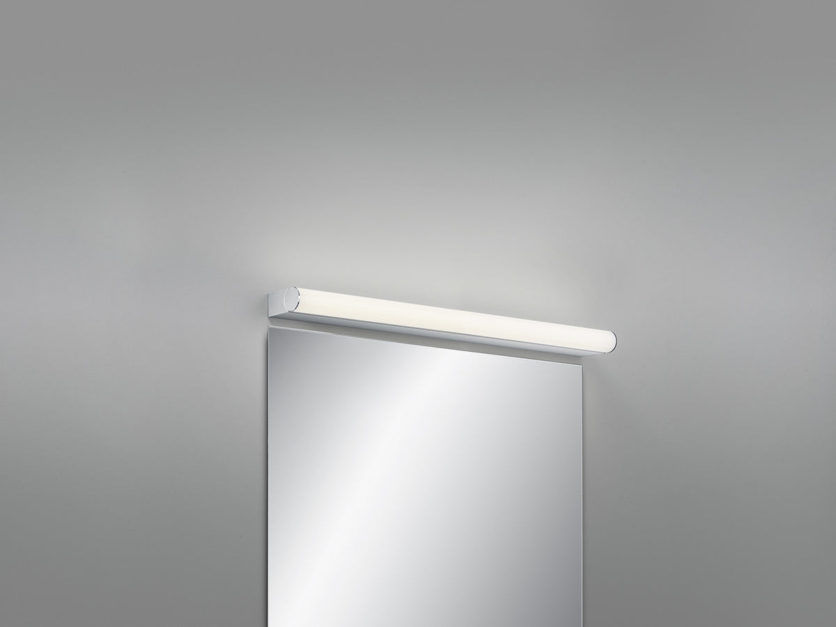 Applique murale chromée allumée, fixée horizontalement au-dessus d'un miroir de salle de bain