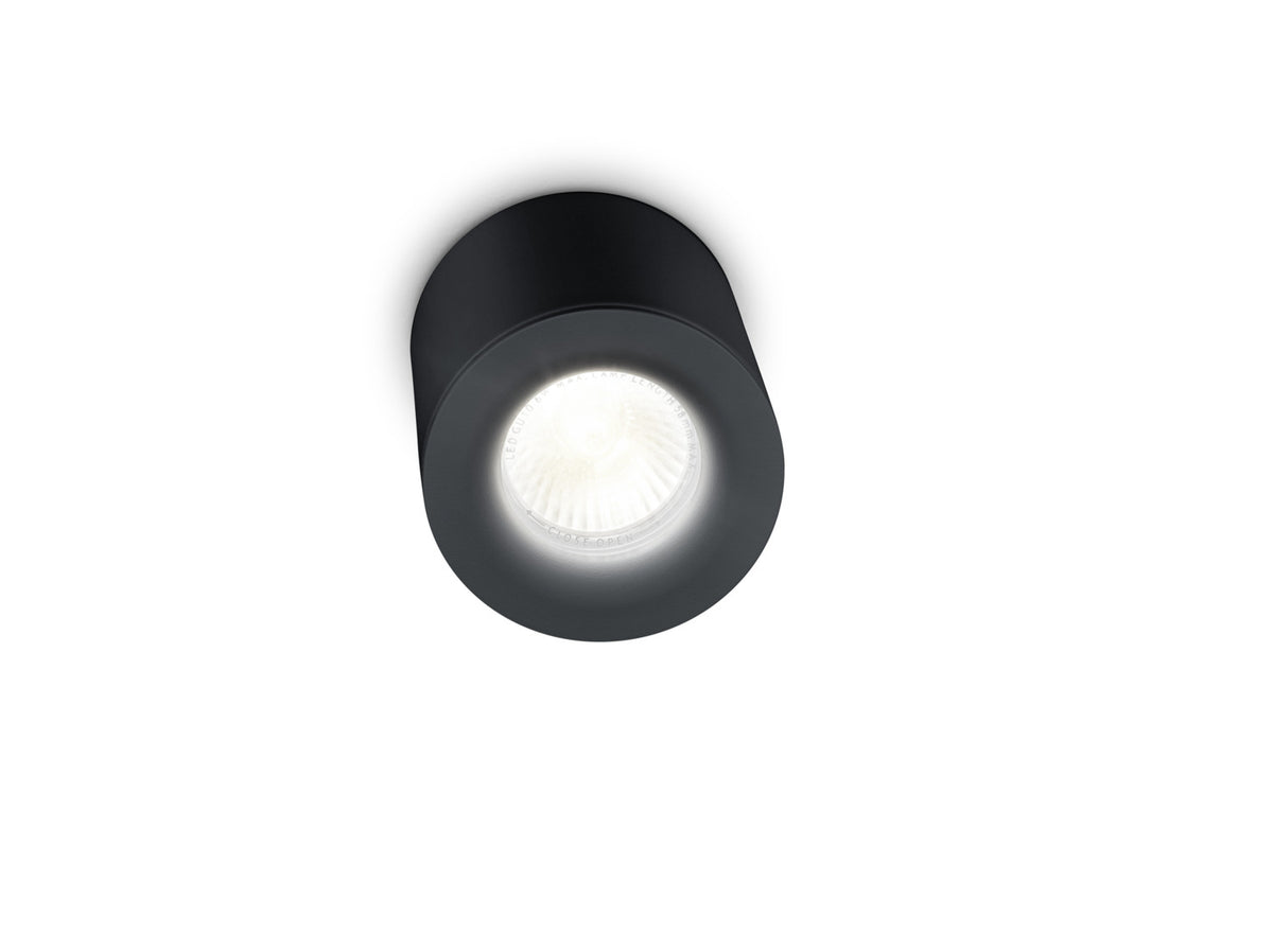 Gros plan du bas du luminaire allumé, montrant lentille et inscriptions sur la bague.