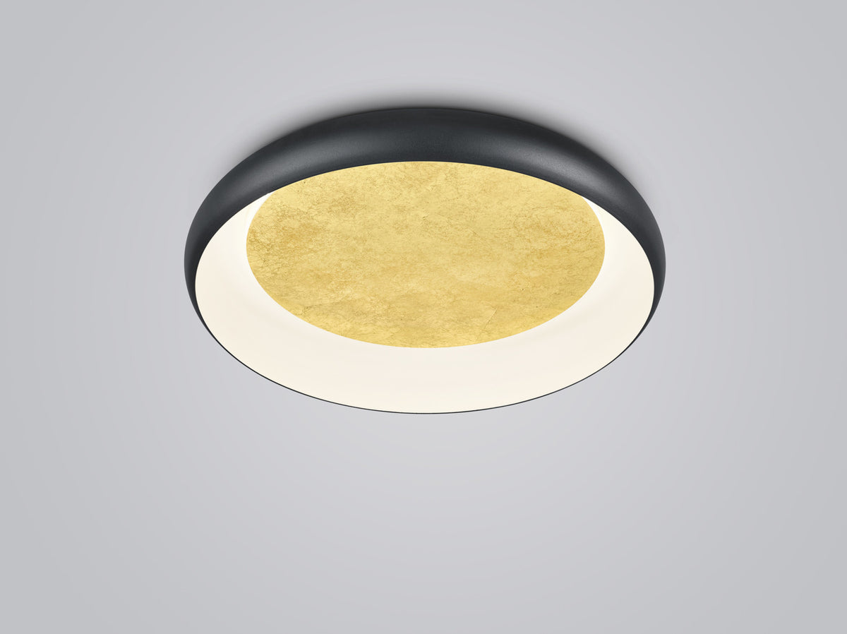 Plafonnier rond noir vu de trois quarts avec disque central doré et diffuseur blanc