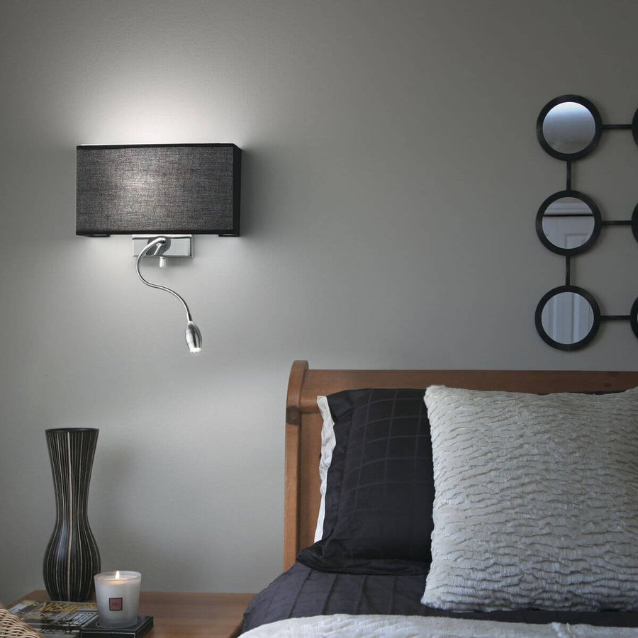 Applique murale noire installée dans une chambre au-dessus d'une tête de lit en bois