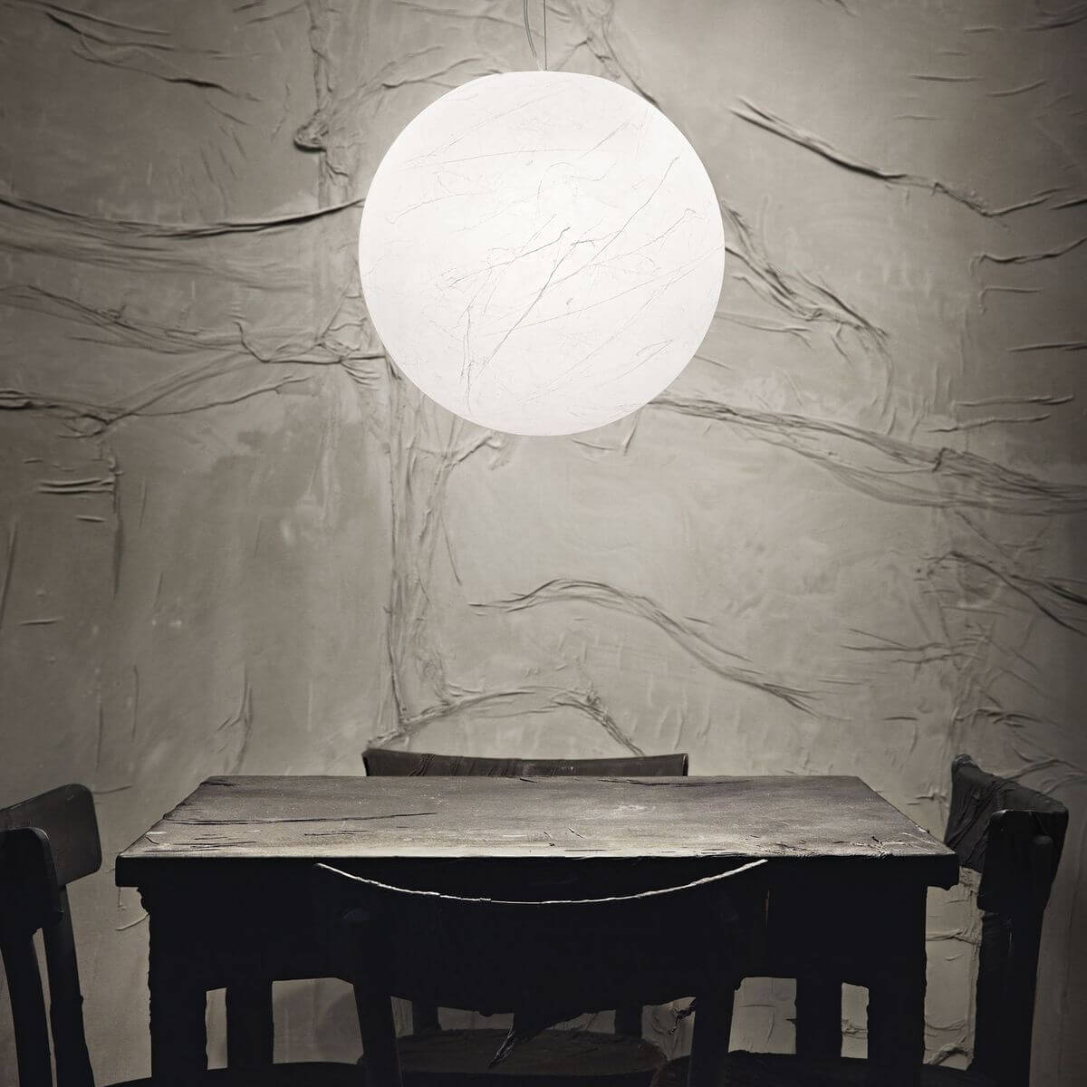 Mise en ambiance au-dessus d'une table, suspension blanche éclairée dans une salle à manger