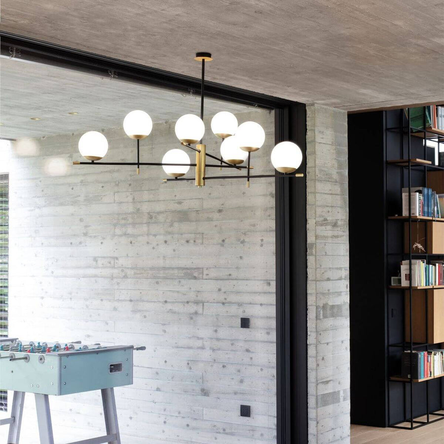 Suspension au-dessus d'un baby-foot dans un intérieur béton et bibliothèque noire.
