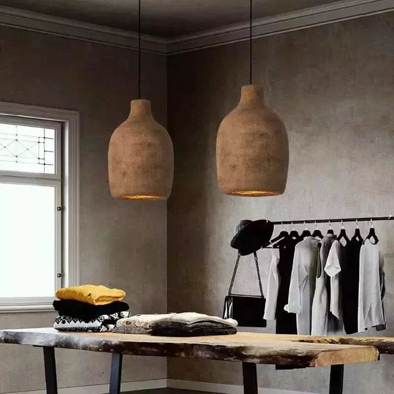 Deux suspensions style pierre marron en duo dans un interieur wabi-sabi au-dessus d'une table en bois brut