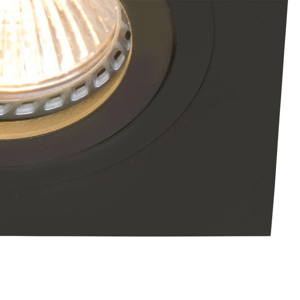 Détail serré de la lentille facettée et de l'anneau intérieur, lumière chaude.