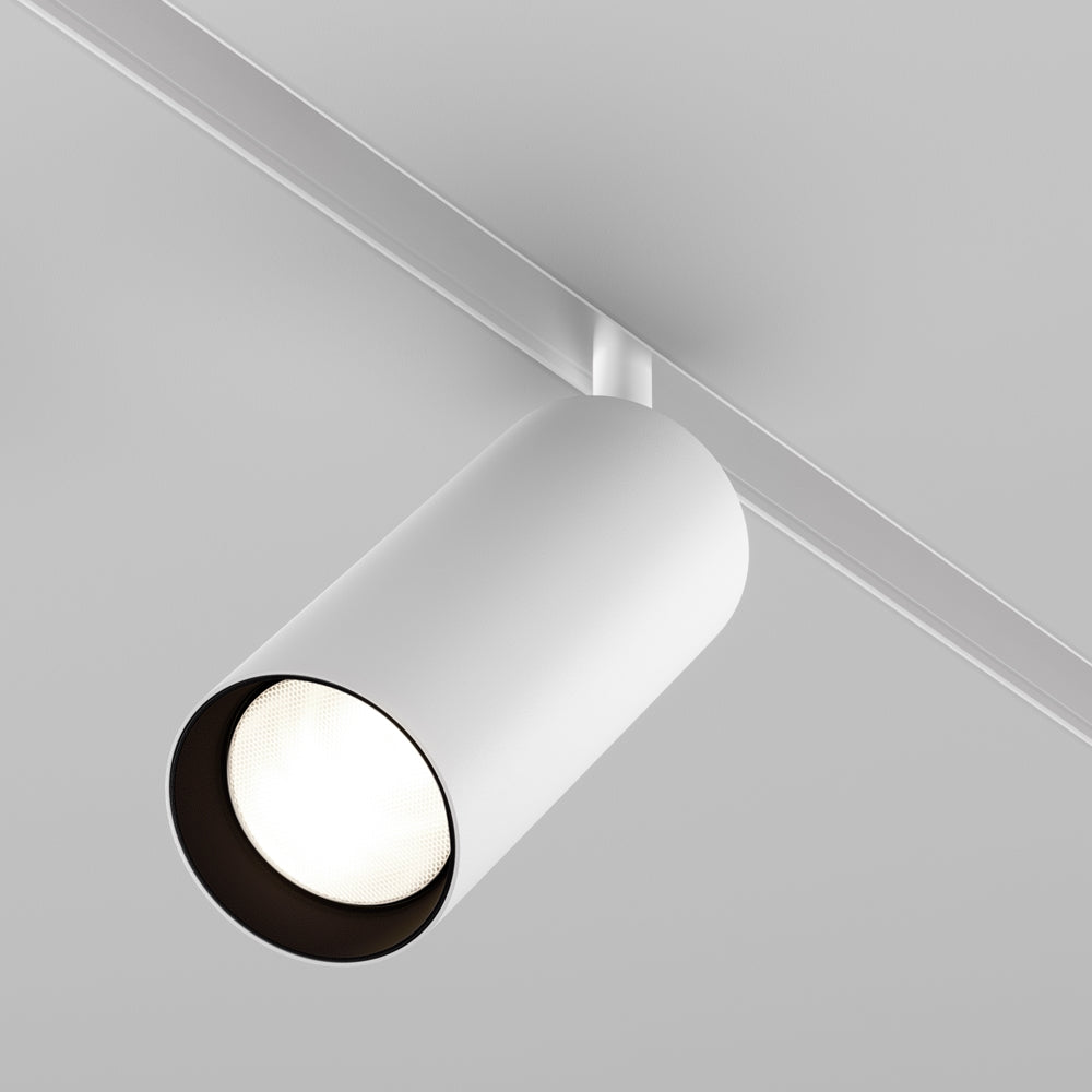 Spot cylindrique blanc fixé sur un rail blanc, orienté vers le bas depuis le plafond.