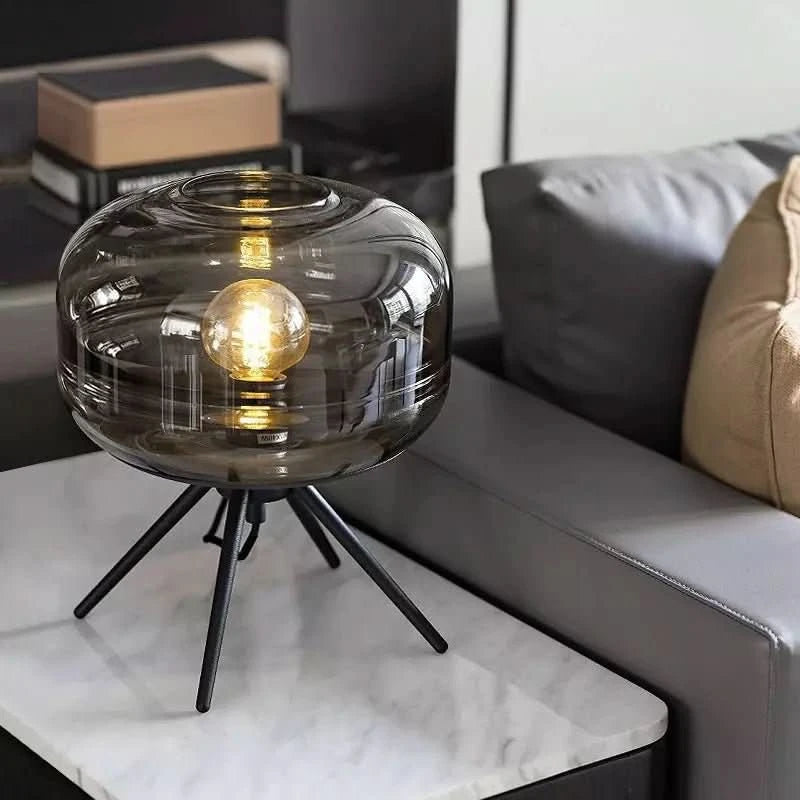 Lampe posée sur table basse en marbre devant un canapé gris