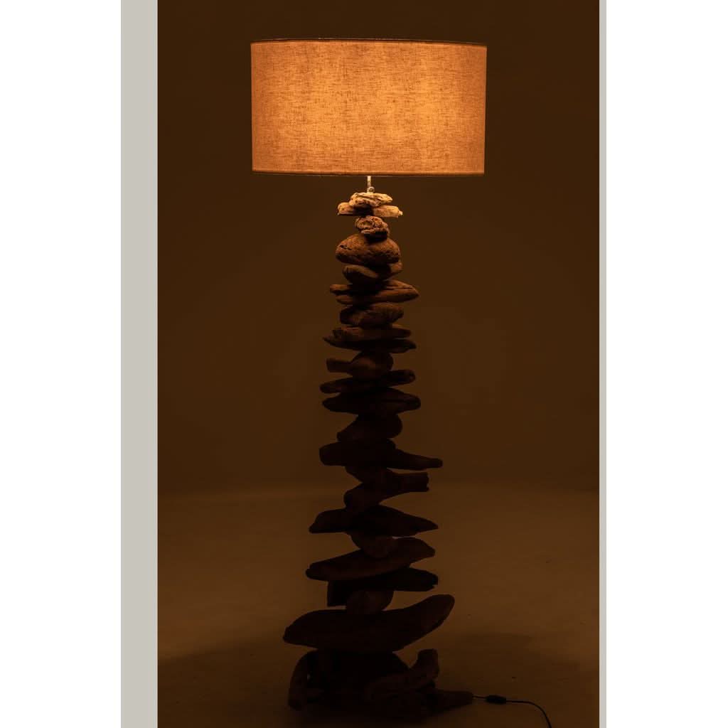 Lampe allumée dans une pièce sombre, abat-jour beige diffusant une lumière chaude