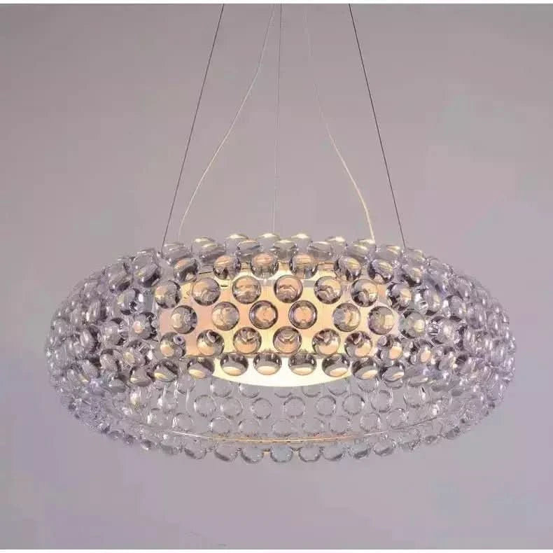 Luminaire allumé laissant voir le diffuseur central doré et ses reflets