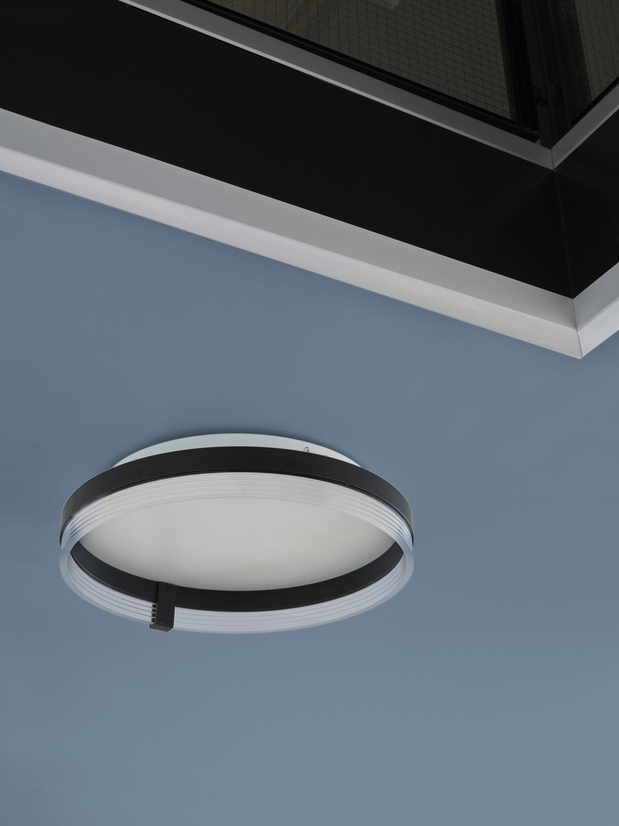 Vue rapprochée du plafonnier fixé au plafond bleu, anneau noir apparent.