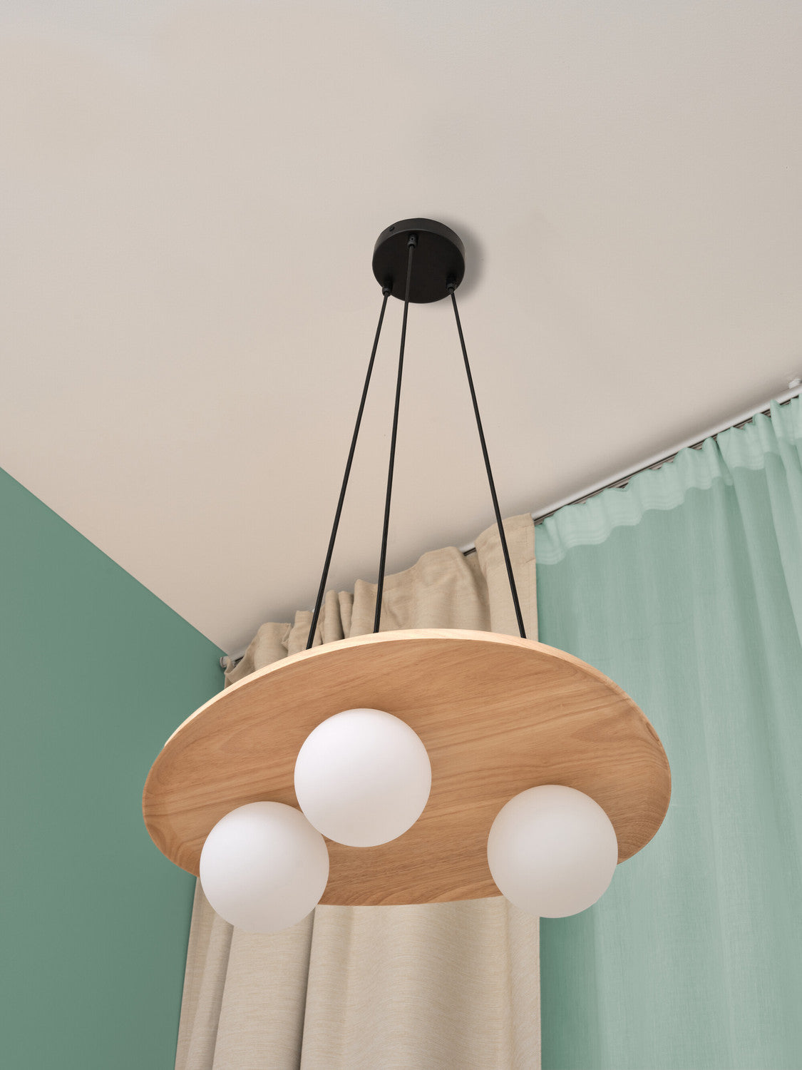 Vue en contre-plongée de la suspension en bois devant rideaux et plafond.