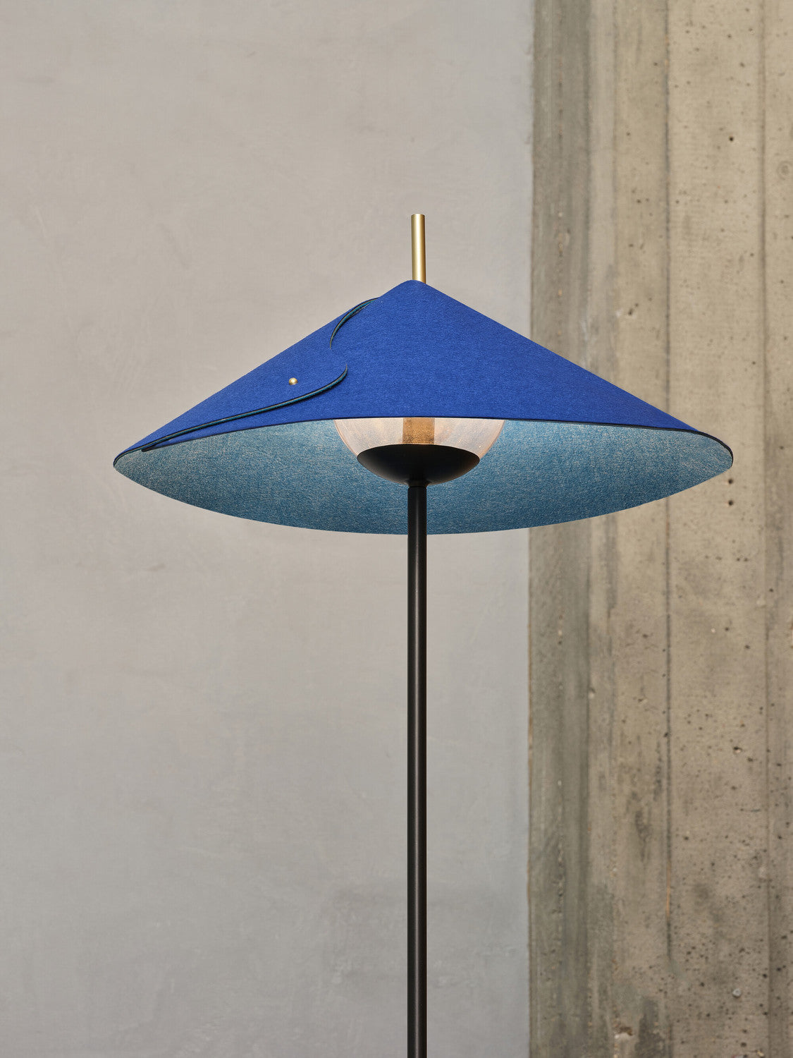 Vue de dessous de l'abat-jour bleu dévoilant la douille et l'intérieur en feutre.