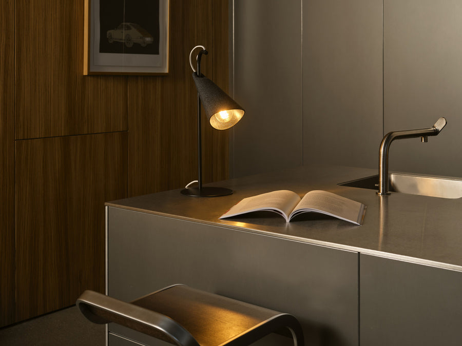 Lampe allumée sur un plan de travail, près d'un livre ouvert