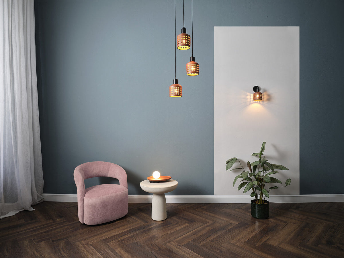 Mise en ambiance avec applique murale allumée et suspensions assorties sur fond bleu.