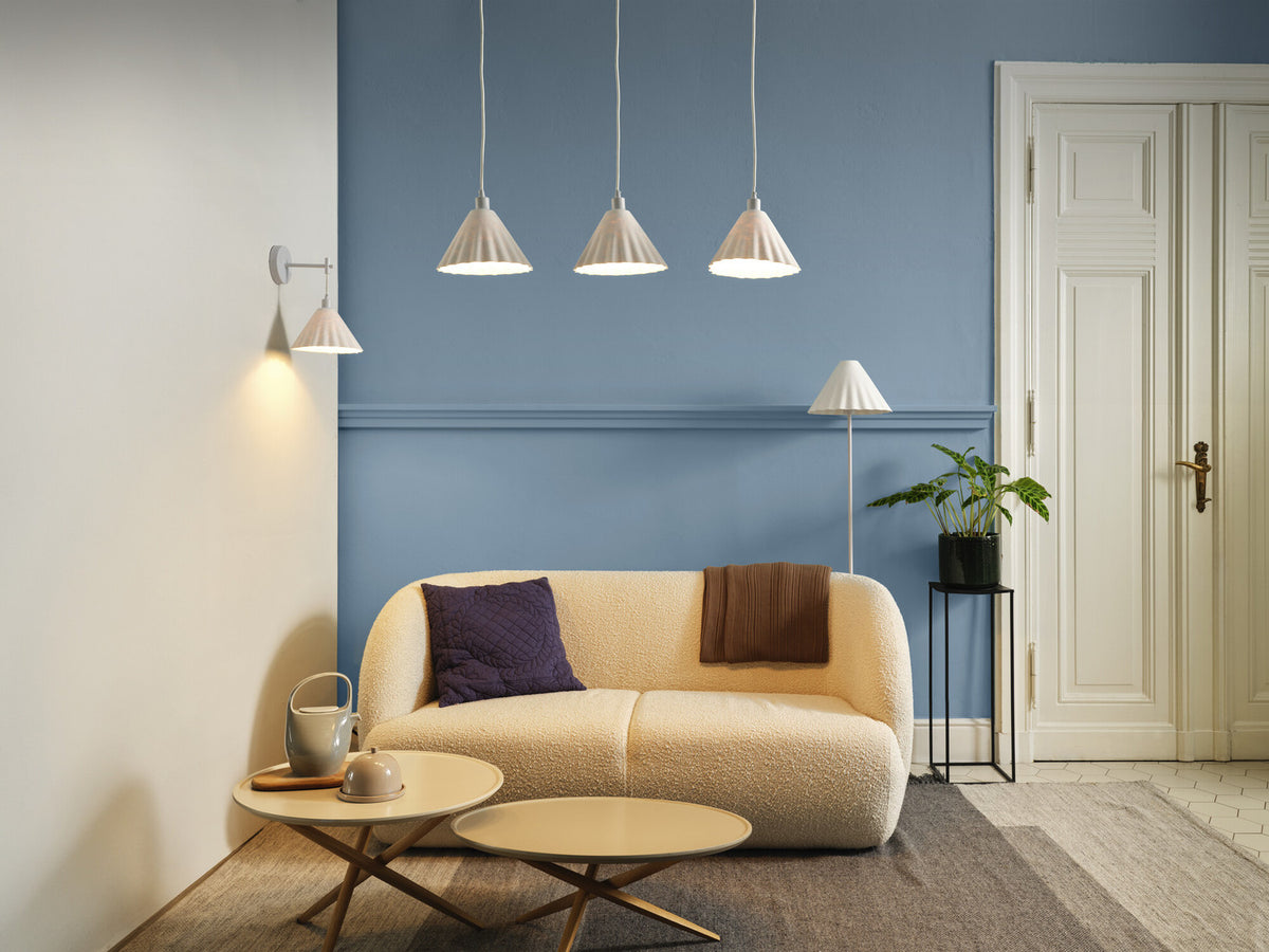 Mise en ambiance avec applique murale et suspensions dans un séjour bleu