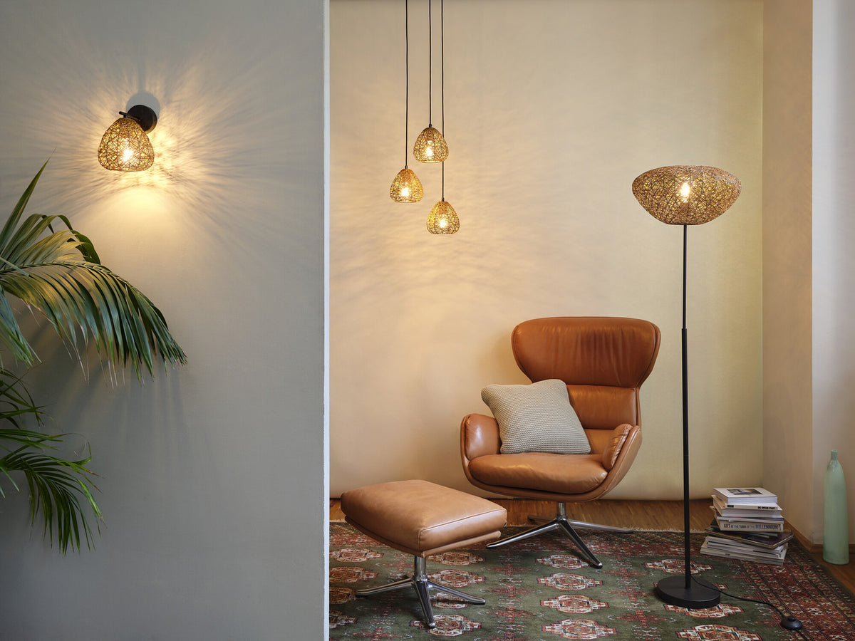 Ambiance avec le lampadaire et d’autres luminaires assortis dans un salon chaleureux.