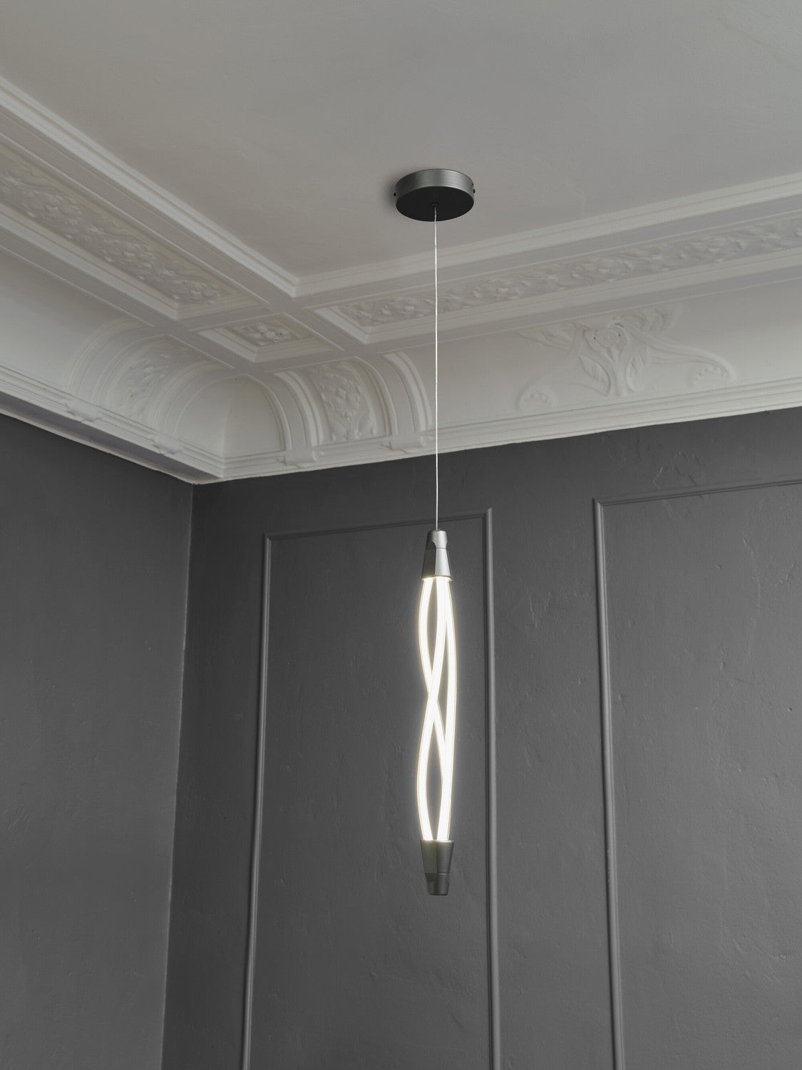 Vue en contre-plongée de la suspension allumée sous une moulure de plafond