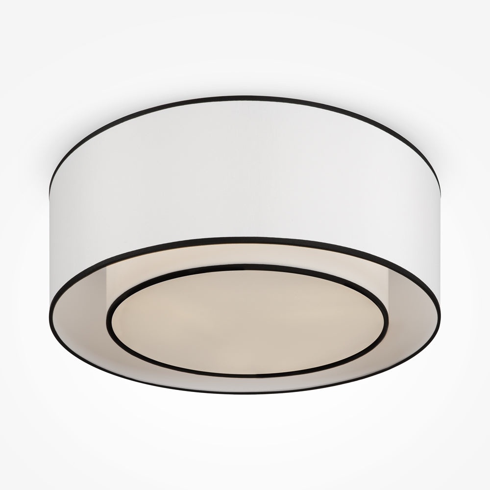 Plafonnier blanc cylindrique vu de dessous, cercles noirs soulignant les bords