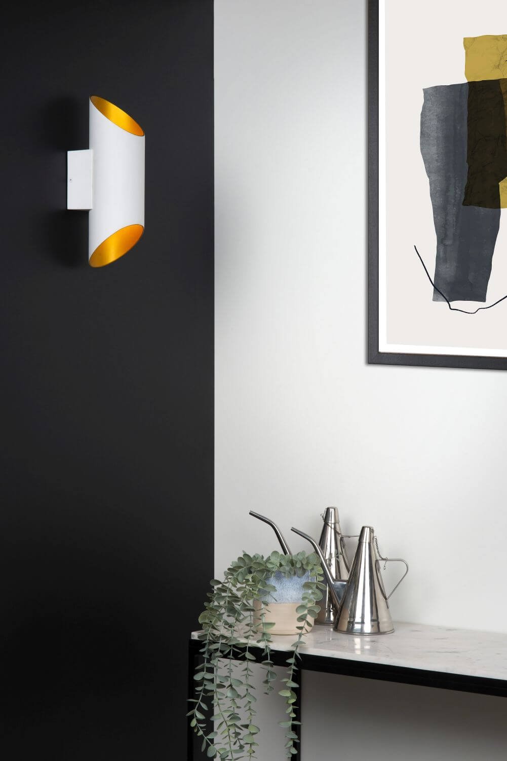Mise en ambiance avec l'applique murale blanche et dorée, cadre et arrosoirs.