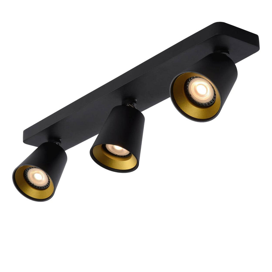 Vue en plongée du luminaire trois spots noirs et dorés sur fond blanc