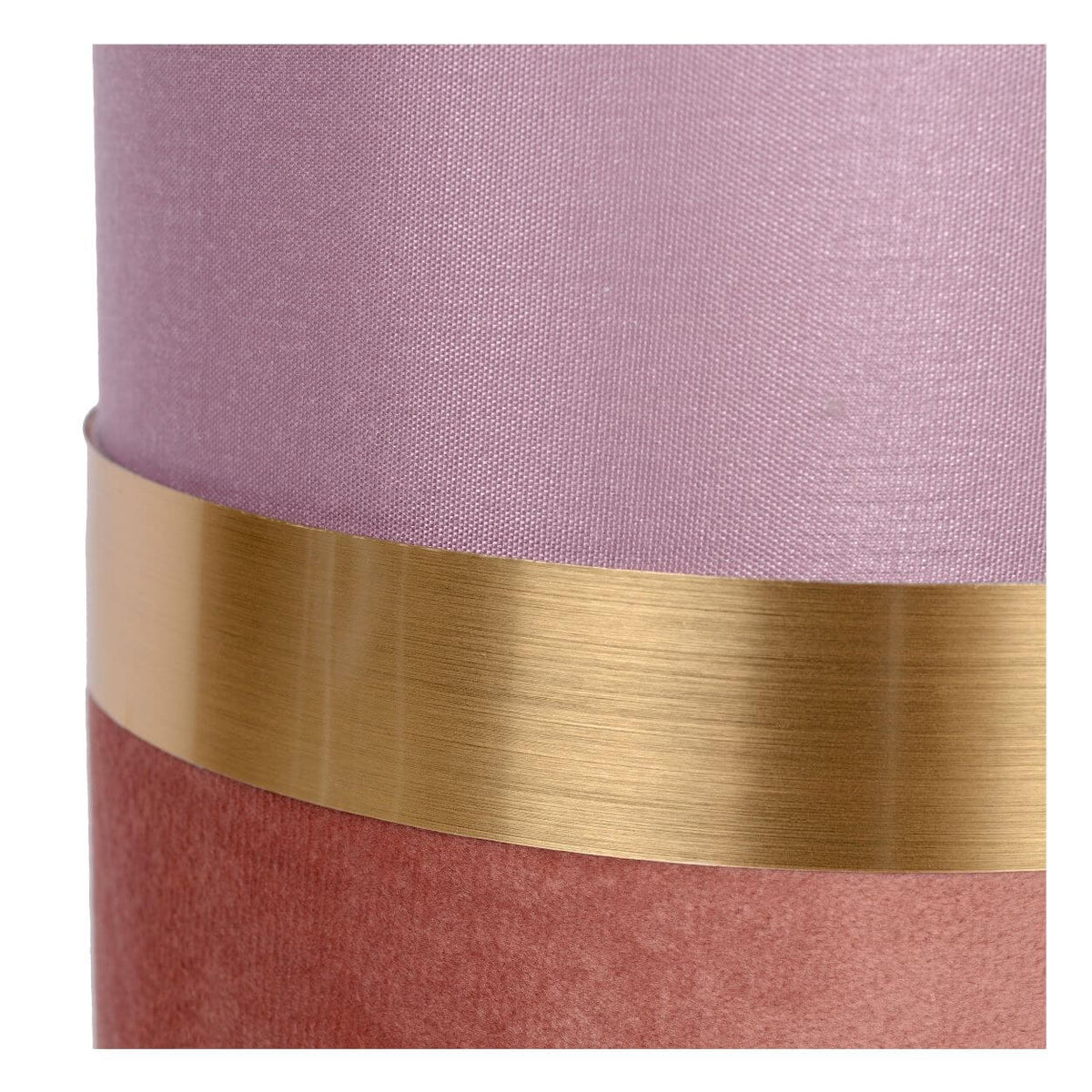 Détail de la finition : tissu rose, bande dorée brossée et base en velours.