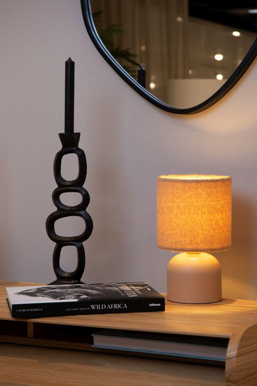 Vue rapprochée de la lampe à poser en tissu bouclé et de son pied arrondi beige.