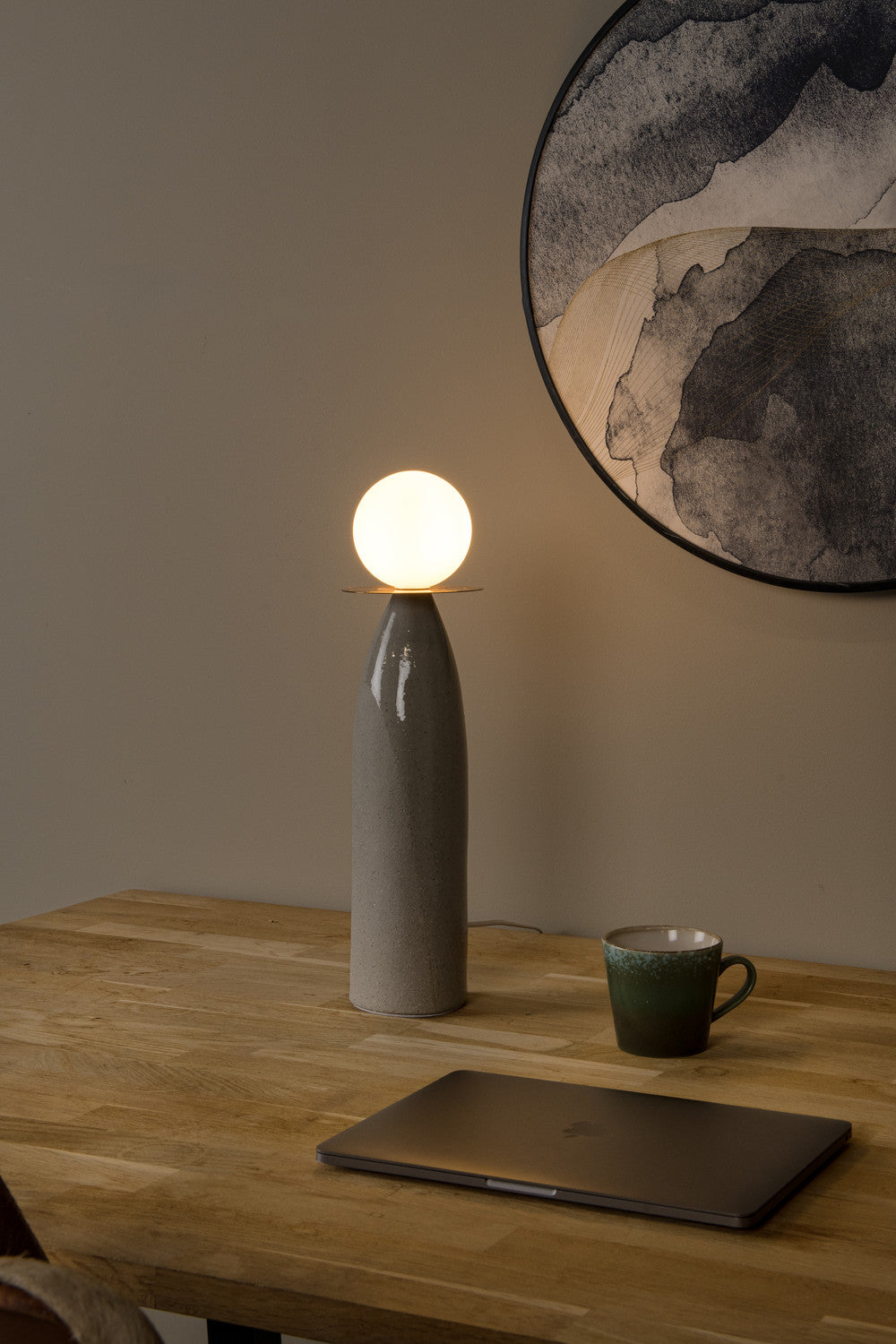 Vue rapprochée de la lampe allumée sur une table en bois, cadre arrondi au mur
