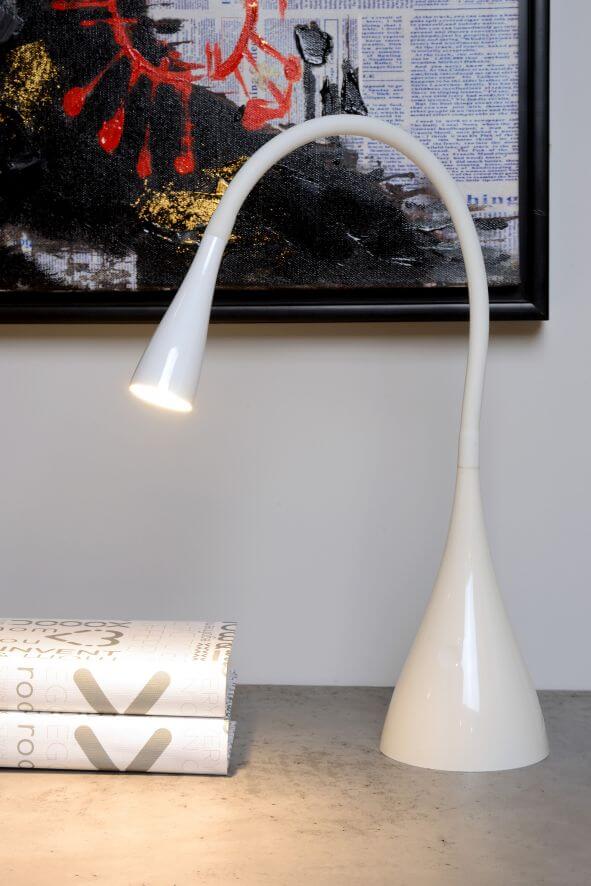 Vue rapprochée du luminaire blanc au col flexible, éclairant deux livres superposés