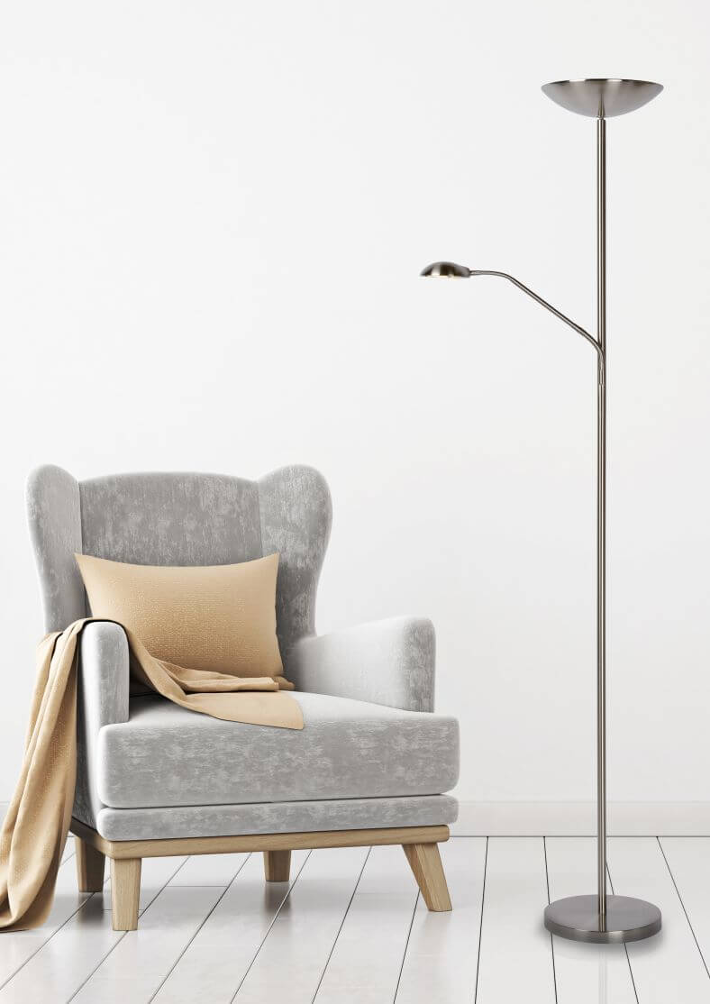 Vue en pied du lampadaire chromé au-dessus d'un fauteuil gris avec coussin beige.
