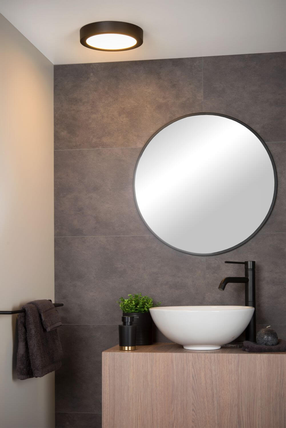 Vue d'ambiance du plafonnier rond noir installé au plafond d'une salle de bain