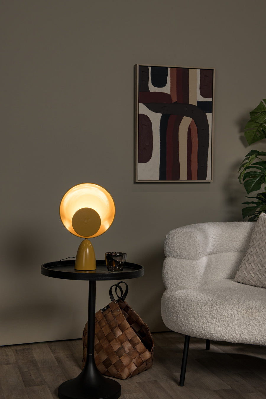 Vue rapprochée de la lampe jaune sur sa table, canapé en bouclette et plante