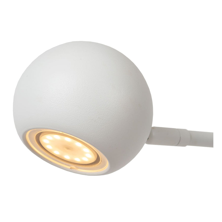 Gros plan sur la tête sphérique blanche et ses LED allumées en dessous.