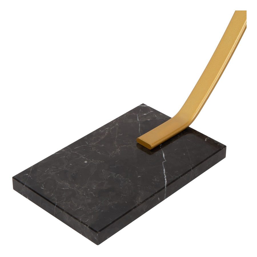 Gros plan sur la base rectangulaire en marbre noir et l'attache dorée.