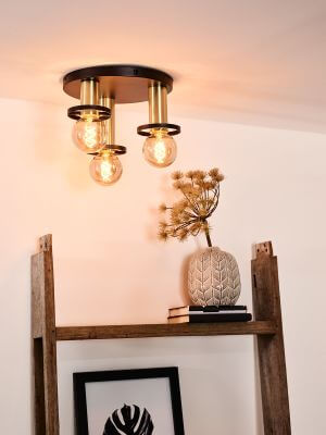 Luminaire installé au plafond au-dessus d'une étagère en bois avec vase et cadre.