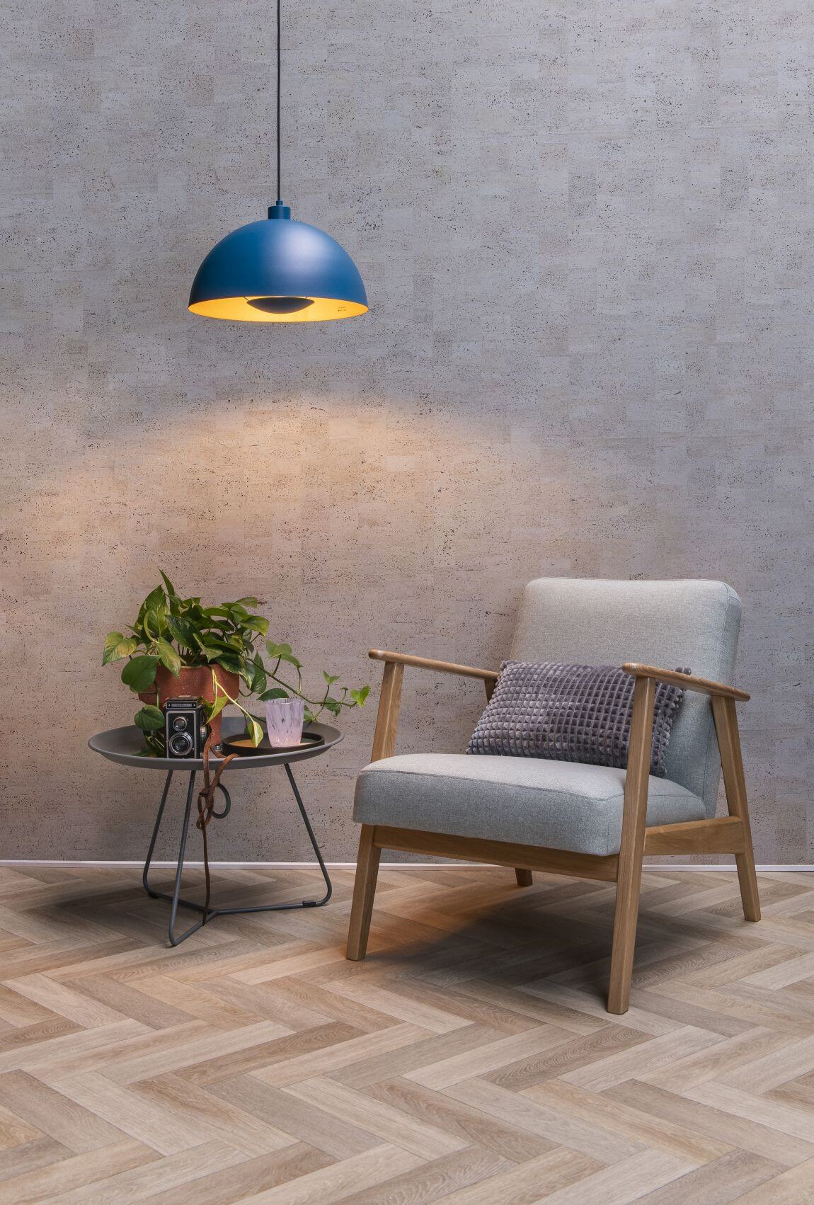 Mise en ambiance d'un coin salon avec fauteuil en bois clair et coussin texturé