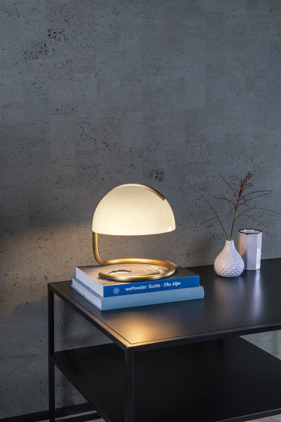 Vue rapprochée de la lampe allumée posée sur une pile de livres.