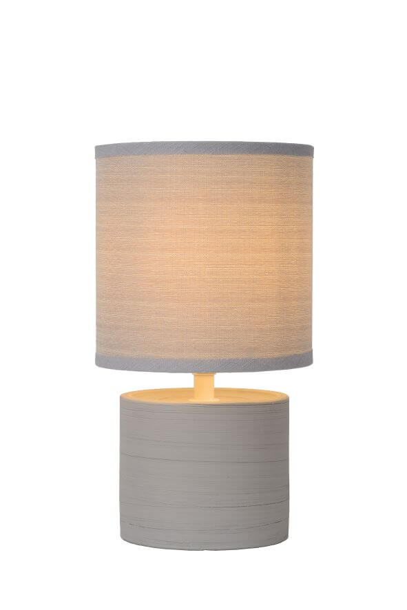 Photo détourée du luminaire gris, abat-jour cylindrique allumé sur fond blanc.